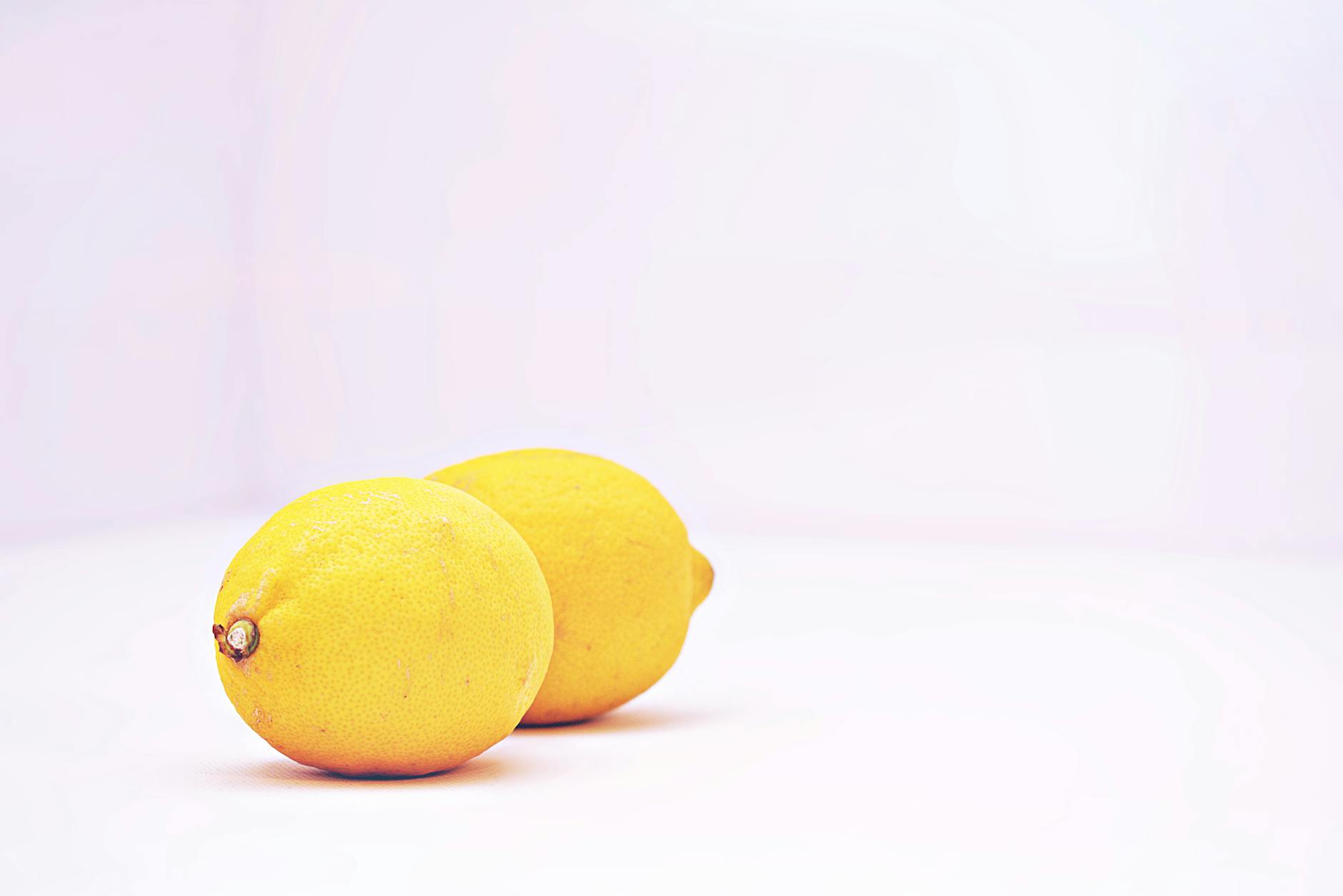 Fresh lemons on a minimalist white background, symbolizing renewal and fresh starts
