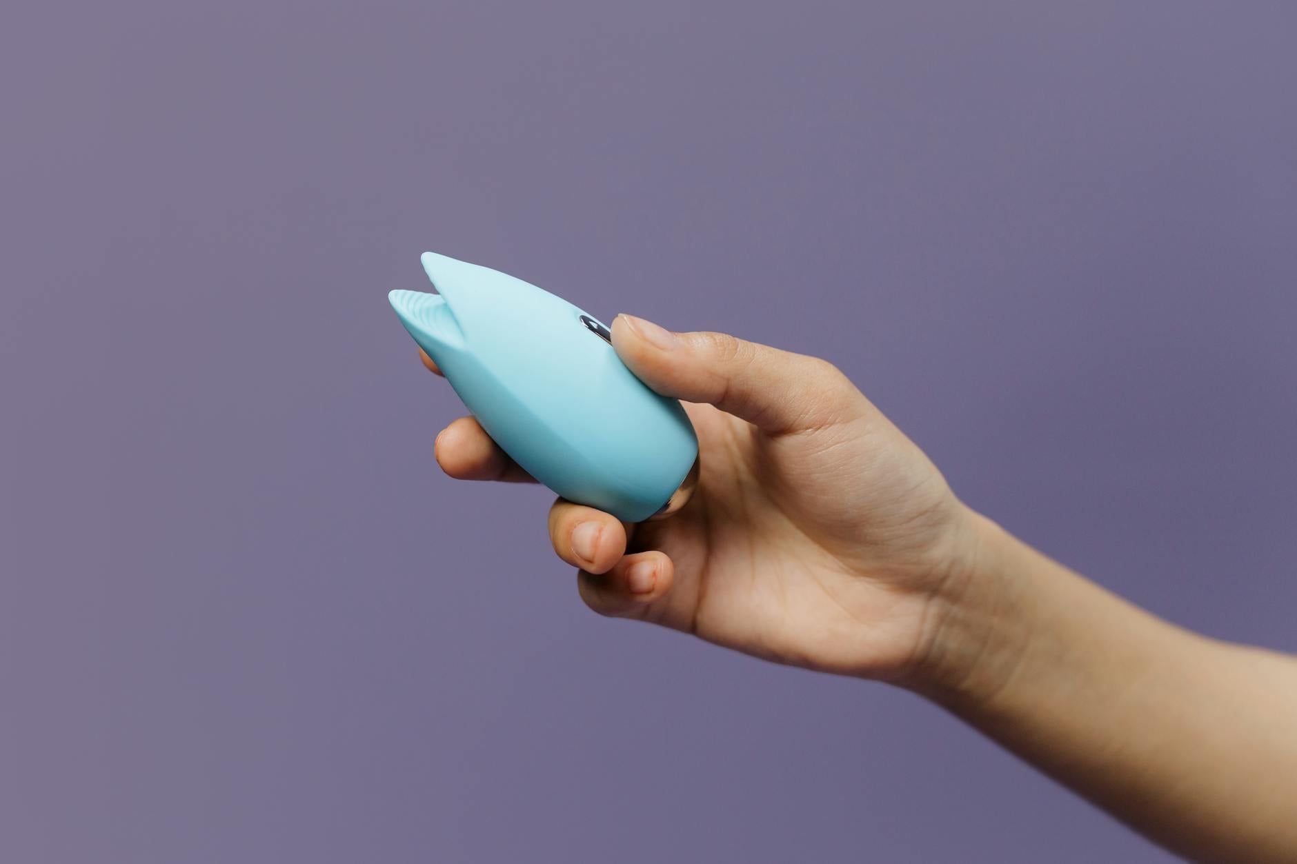Woman holding lemon vibrators in contemplative pose, exploring pleasure over 40