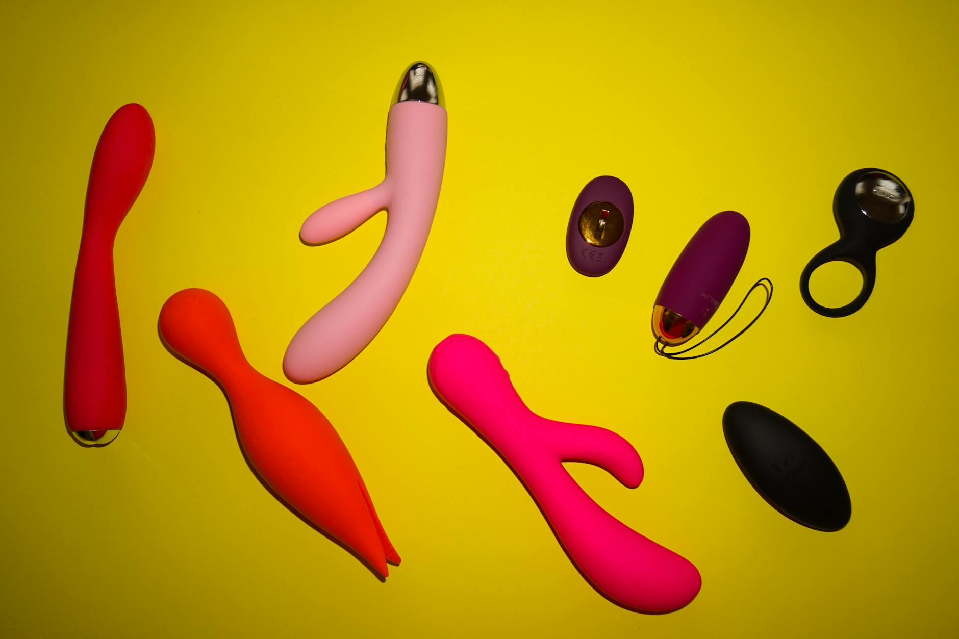 Colorful collection of lemon clitoral vibrators and toys on bright yellow surface