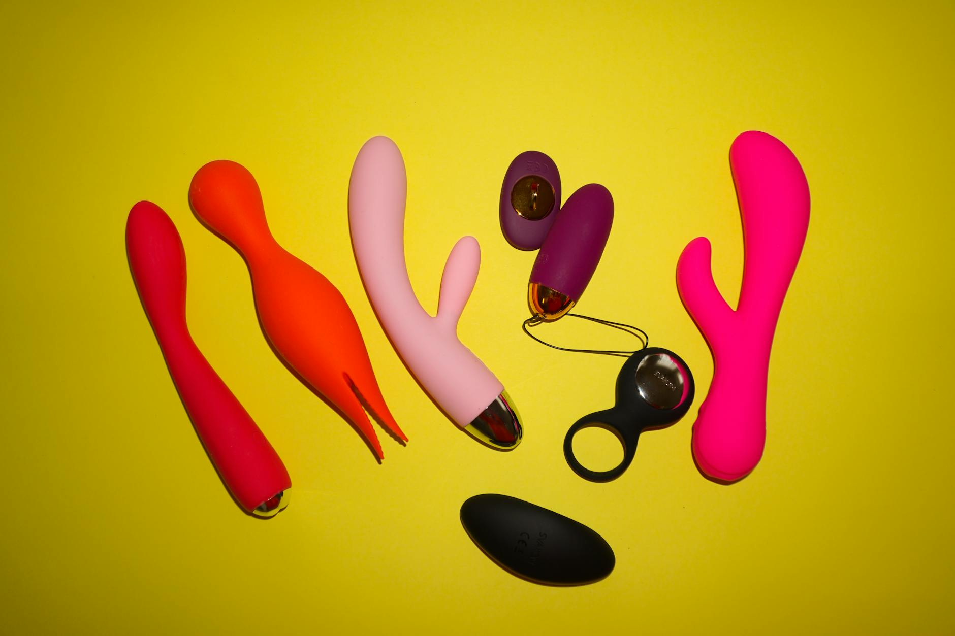 Hands holding a sleek lemon clitoral vibrator against a purple background